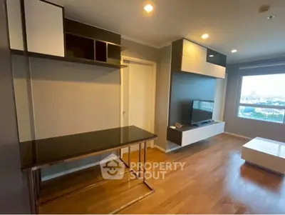 Modern living room with sleek furniture and large window offering city view