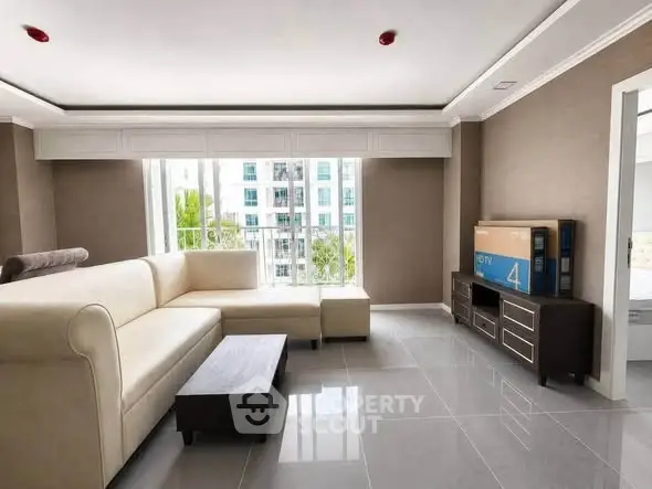 Spacious modern living room with large windows and elegant furniture in a high-rise apartment.