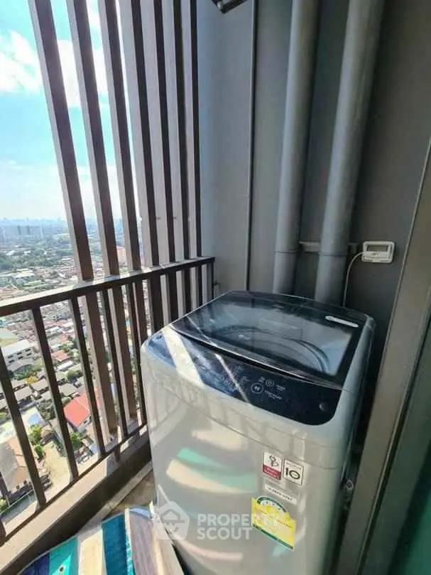 High-rise balcony with washing machine and city view, perfect for urban living convenience.