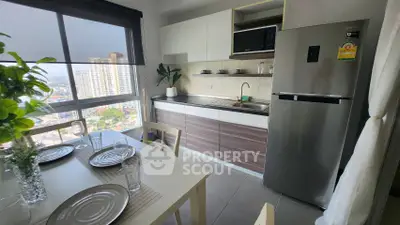 Modern kitchen with dining area and city view, featuring sleek appliances and stylish decor.