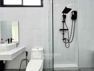 Modern bathroom with sleek shower and elegant marble sink in a contemporary home.