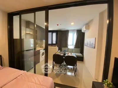 Modern apartment with open living and kitchen area featuring sleek design and natural light.