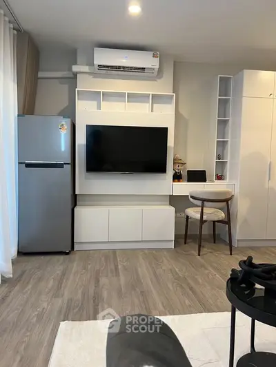 Modern living room with sleek TV unit and air conditioning, featuring stylish flooring and contemporary furniture.