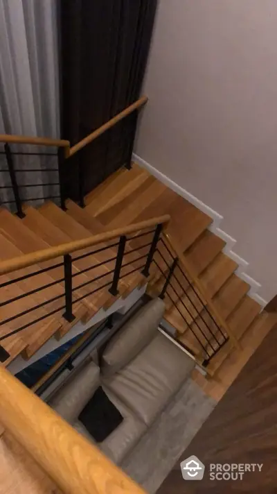 Modern wooden staircase with sleek black railings in a stylish home interior