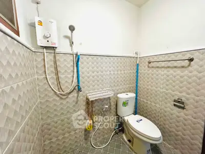 Modern bathroom with tiled walls and electric shower unit