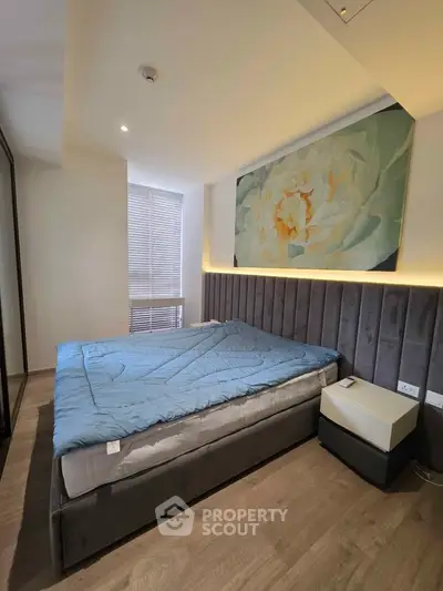 Modern bedroom with stylish decor and cozy ambiance, featuring a large bed and elegant lighting.