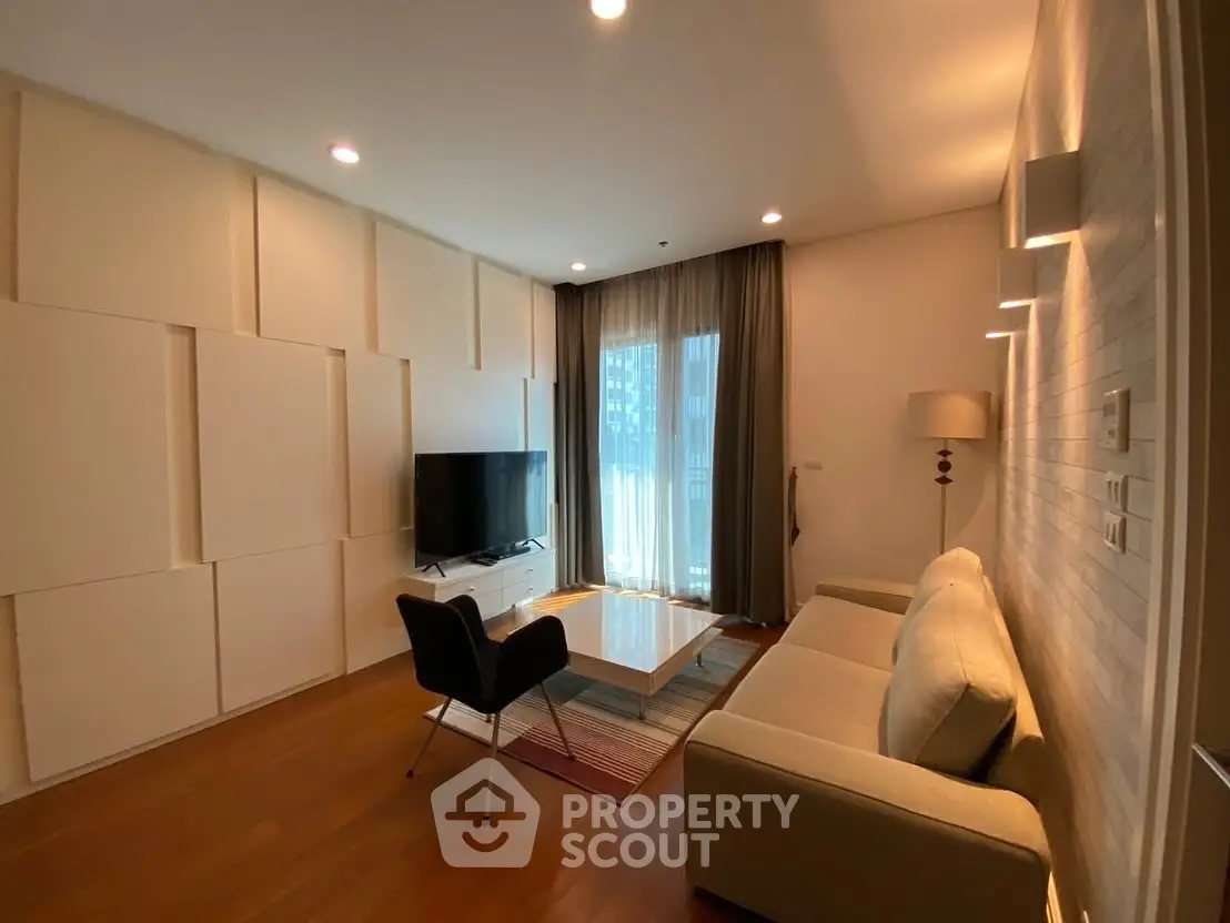 Modern living room with sleek design and large TV, featuring cozy seating and stylish lighting.