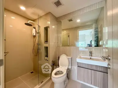Modern bathroom with glass shower and sleek fixtures in a contemporary home.