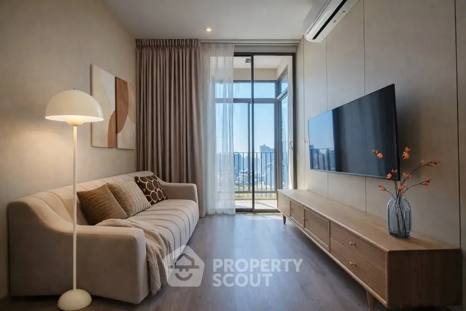 Modern living room with stylish decor and balcony view in a high-rise apartment.