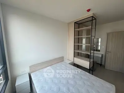 Modern bedroom with minimalist design and large window for natural light.