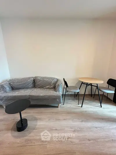 Modern living room with minimalist furniture and wooden flooring, perfect for cozy urban living.