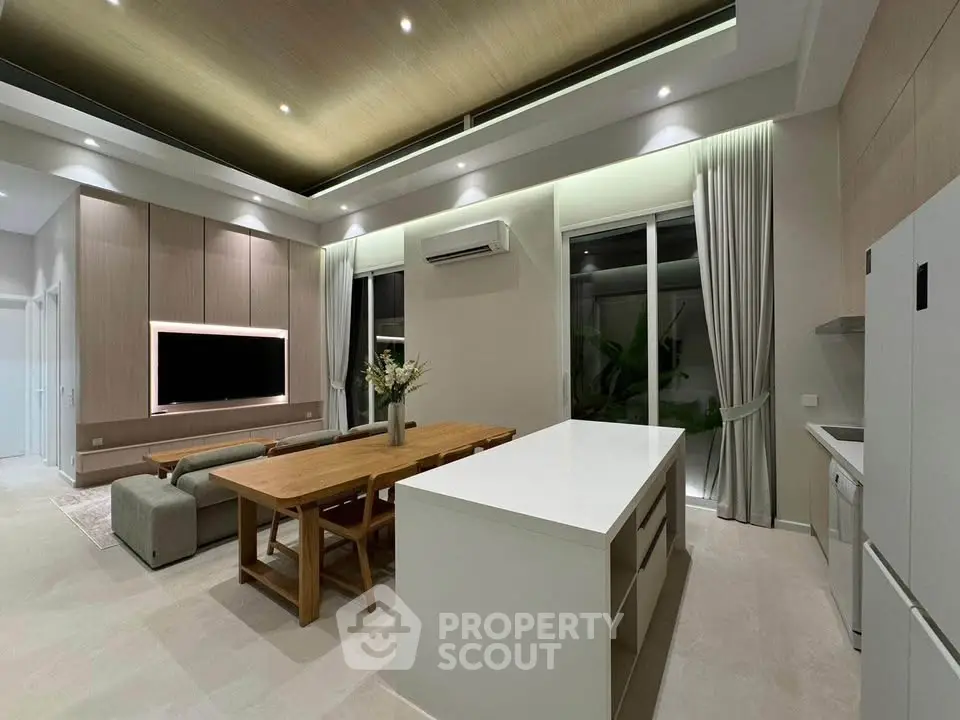 Modern open-layout living room and kitchen with sleek design and ambient lighting
