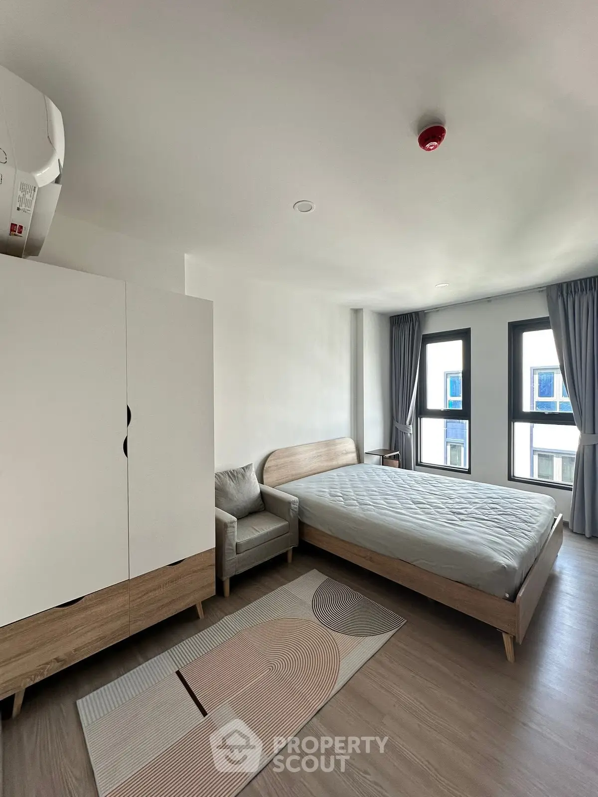 Modern bedroom with minimalist design, featuring large windows and stylish furniture.