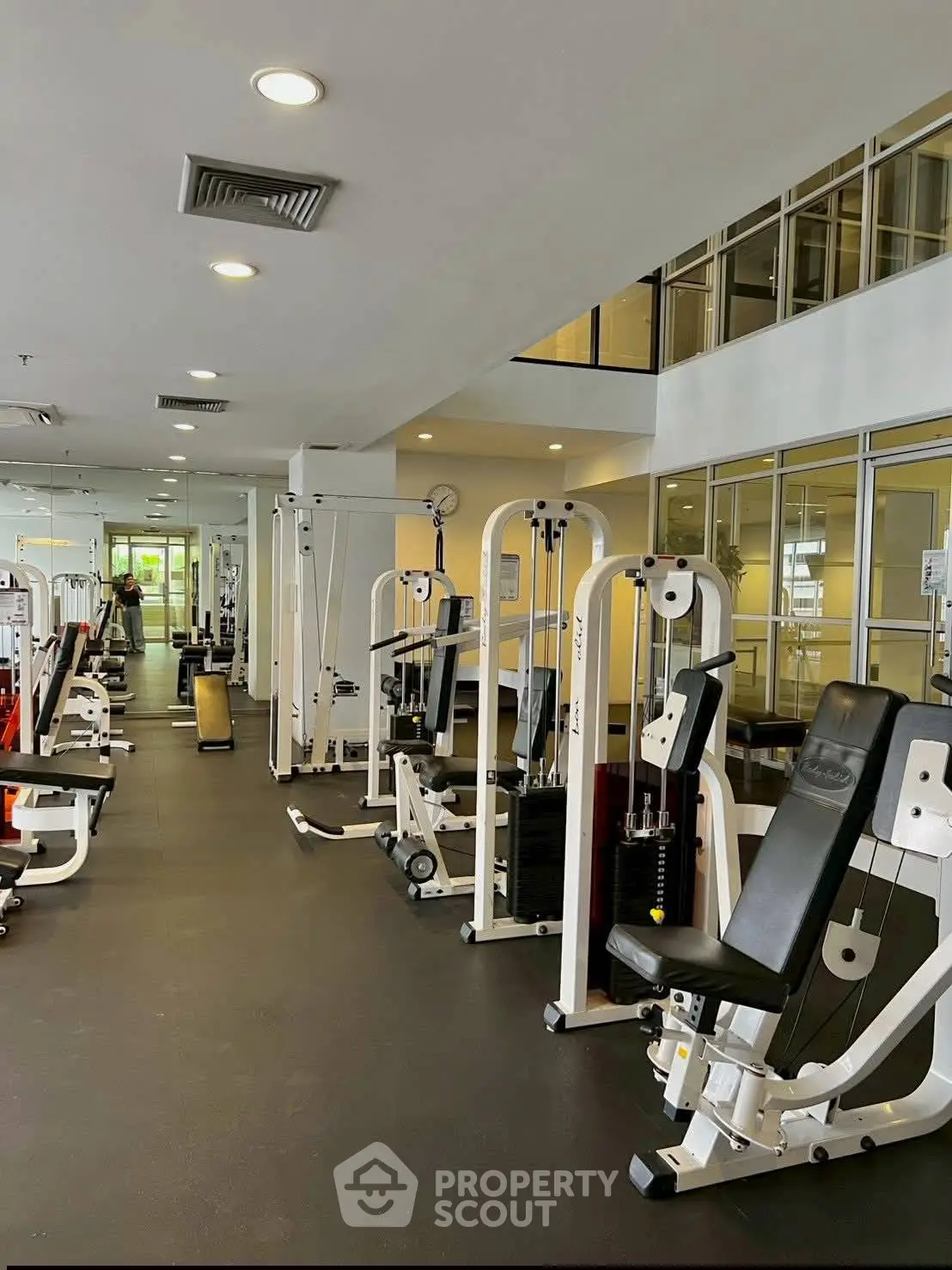 Spacious modern gym with state-of-the-art fitness equipment in a well-lit environment.