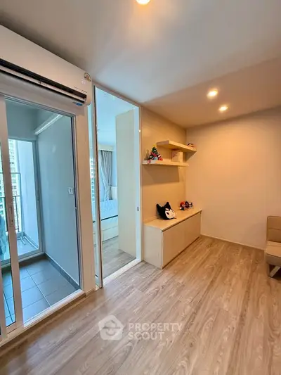 Modern living room with wooden flooring and balcony access in a stylish apartment.