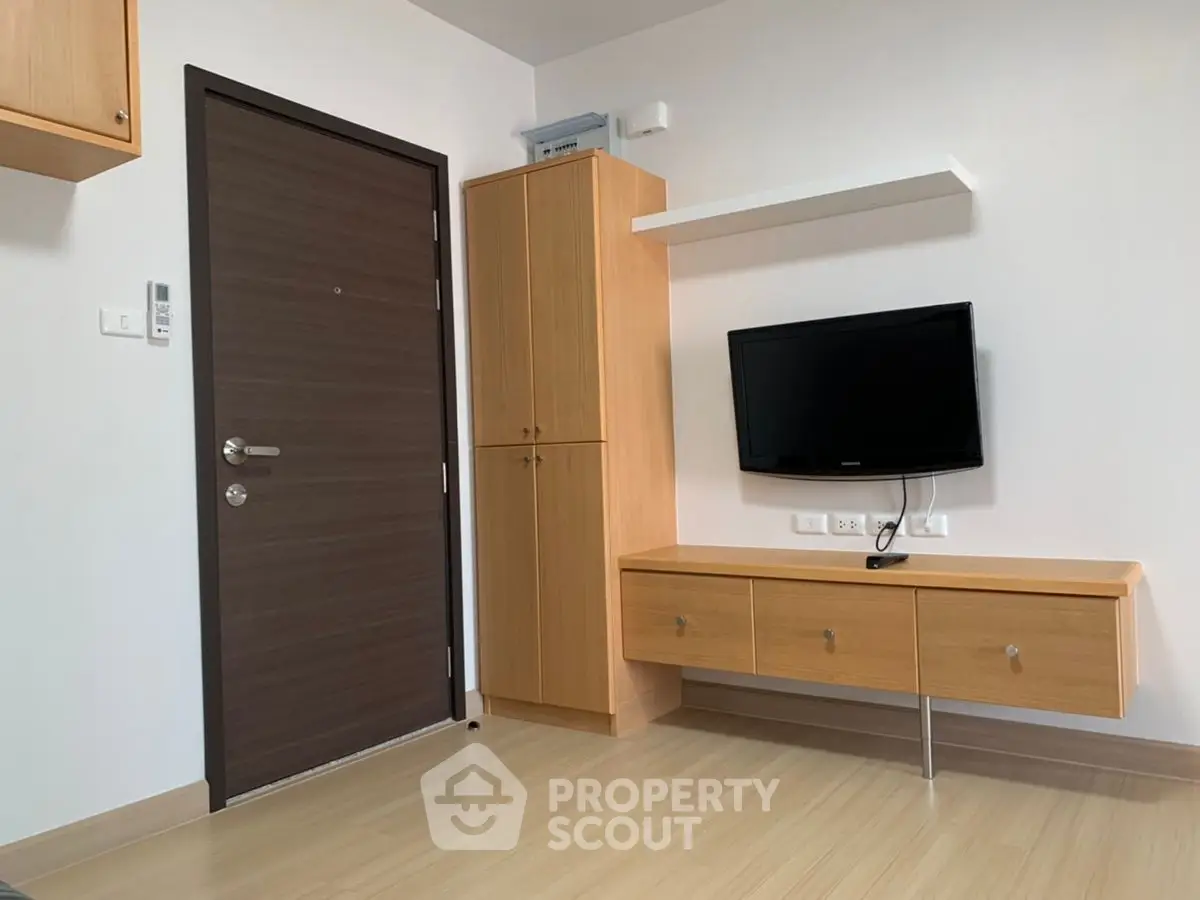 Modern minimalist living room with wooden flooring and wall-mounted TV