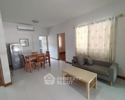 Spacious living room with modern furniture and natural light, perfect for relaxation and entertaining.