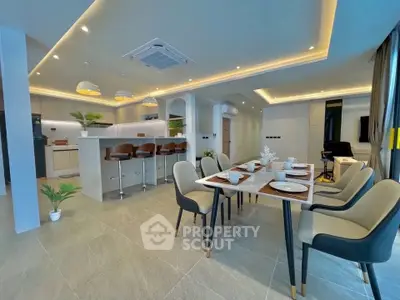Spacious modern kitchen and dining area with elegant lighting and sleek design.
