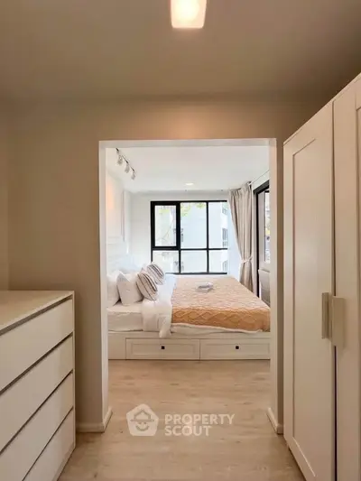 Bright and cozy bedroom with modern furnishings and large windows for natural light.