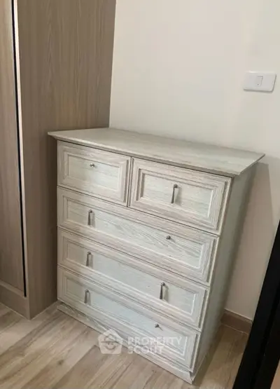 Modern wooden dresser in a stylish bedroom corner with light wood flooring.