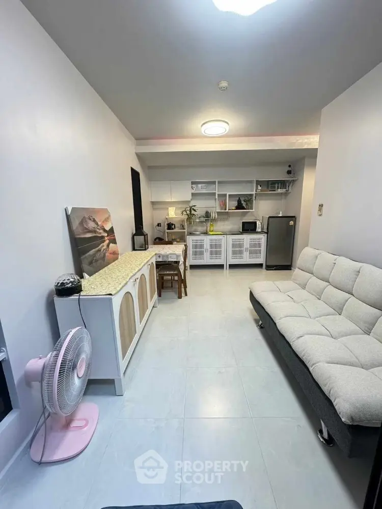 Modern living room with open kitchen, stylish furniture, and cozy ambiance.
