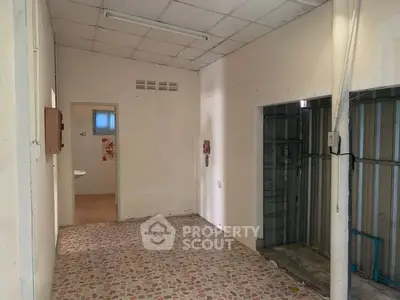 Spacious interior with tiled flooring and access to bathroom, ideal for renovation.