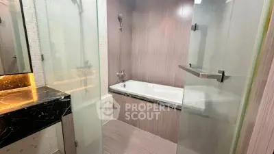 Luxurious modern bathroom with elegant bathtub and sleek glass shower doors.