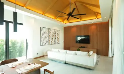 Luxurious living room with modern decor, high ceiling, and elegant lighting
