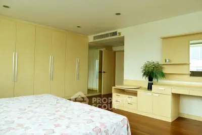 Spacious bedroom with built-in wardrobes and elegant wooden flooring