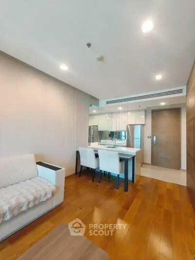 Modern living room with wooden flooring and elegant dining area in a stylish apartment.