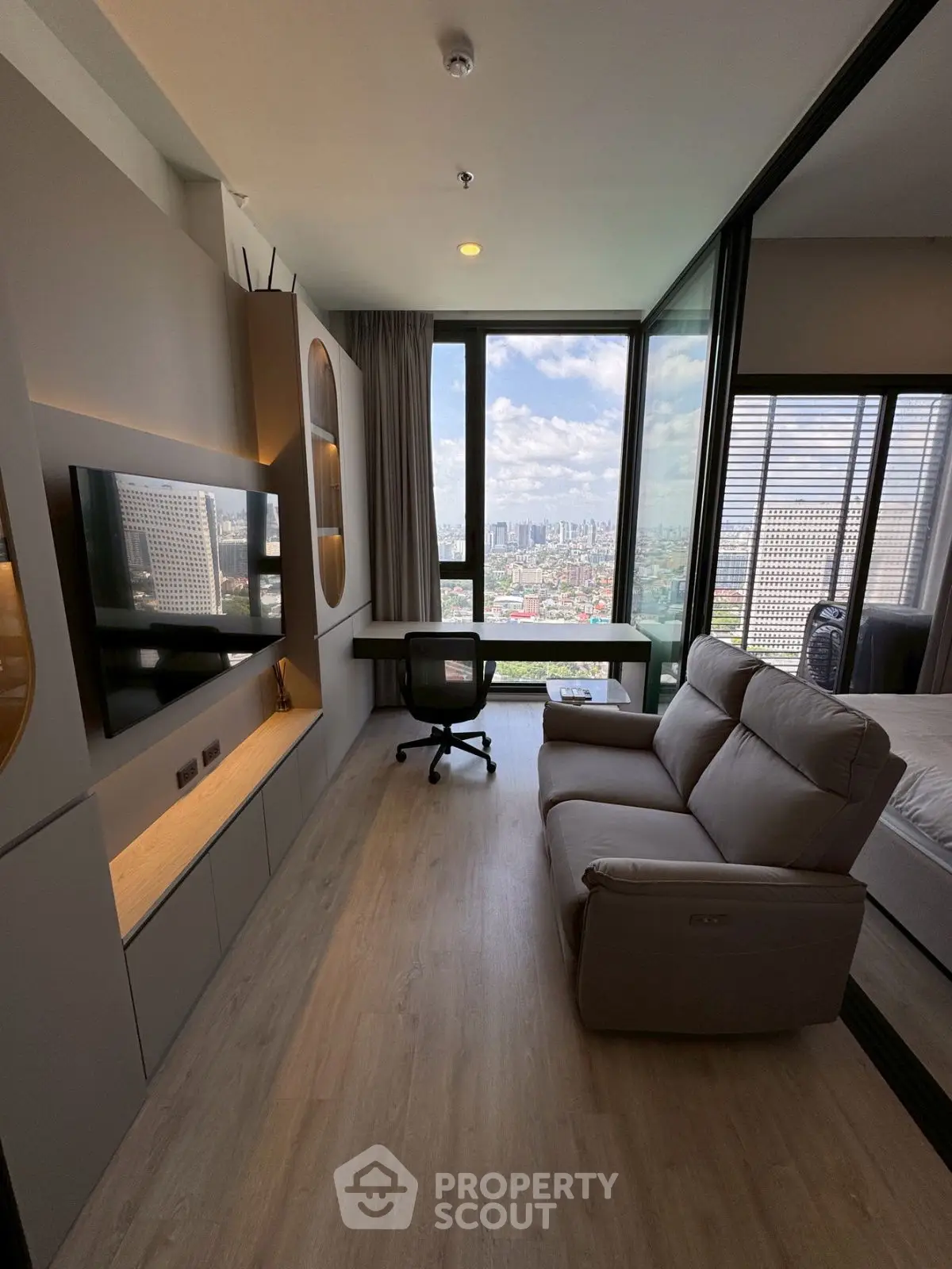 Modern living room with city view, sleek furniture, and natural light.