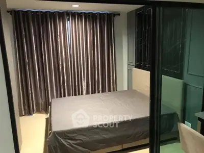 Cozy bedroom with modern glass partition and elegant curtains in a stylish apartment.