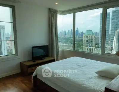 Spacious bedroom with stunning city view in modern high-rise apartment.