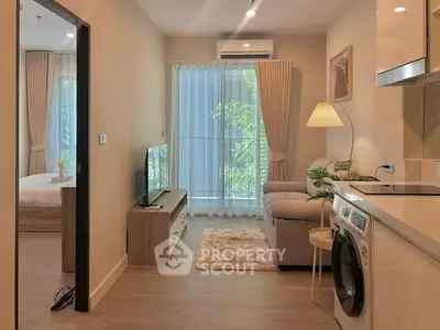 Modern apartment interior with cozy living room and kitchen featuring washing machine and stylish decor.