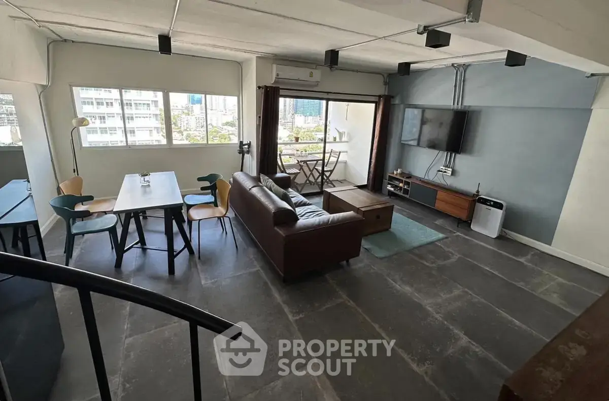 Spacious modern living room with city view, featuring stylish furniture and open layout.
