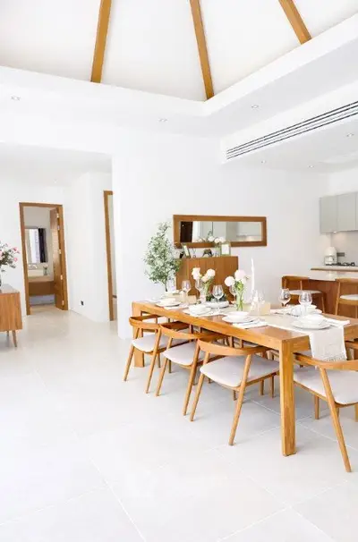 Spacious dining area with elegant wooden furniture and modern kitchen in open layout design.