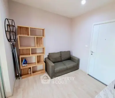 Cozy living room with modern sofa and stylish wooden shelving unit.