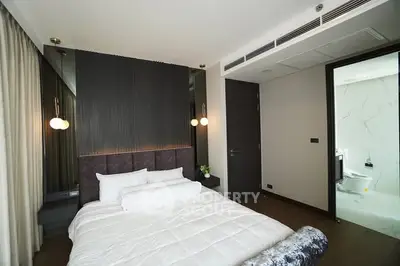 Modern bedroom with elegant decor and ensuite bathroom in luxury apartment