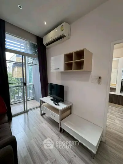 Modern living room with balcony access and sleek furniture in a stylish apartment.