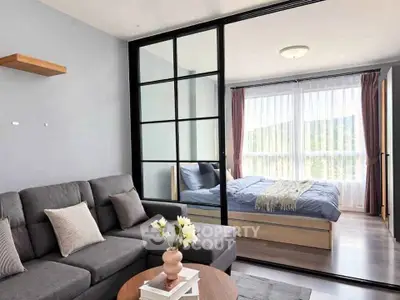Modern living room with sliding glass doors leading to a cozy bedroom with natural light.