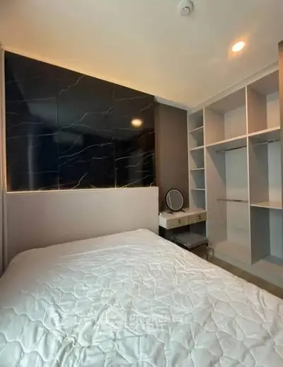 Modern bedroom with sleek black accent wall and built-in storage