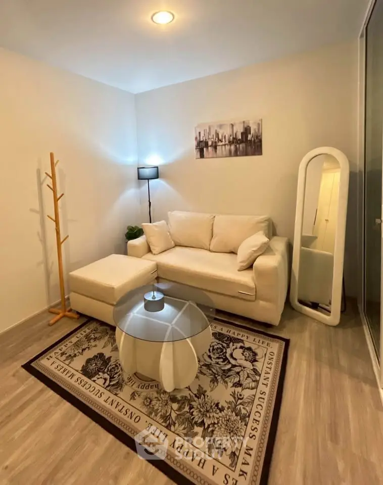 Cozy living room with modern decor, featuring a white sofa, stylish rug, and elegant floor lamp.