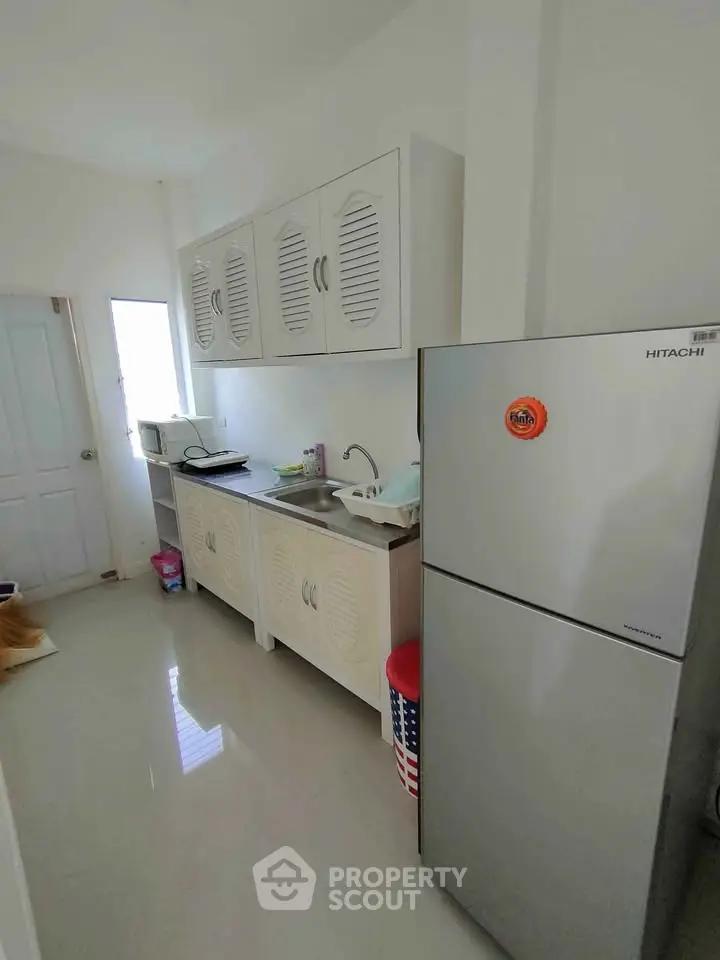 Modern kitchen with sleek cabinets and stainless steel fridge in bright interior