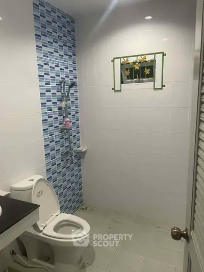 Modern bathroom with blue tile accent wall and white fixtures