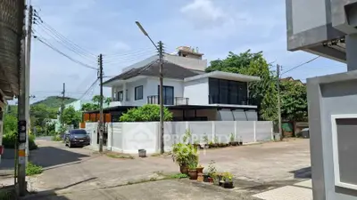 Modern two-story house with sleek design and spacious outdoor area in a quiet neighborhood.