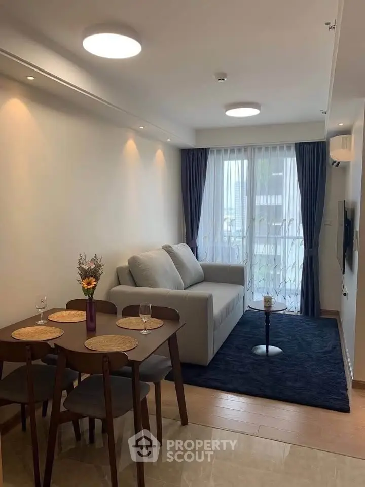 Modern living room with cozy sofa, dining table, and elegant decor in a stylish apartment.