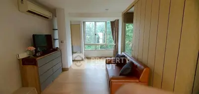 Spacious living room with large windows and modern furnishings in a serene setting.