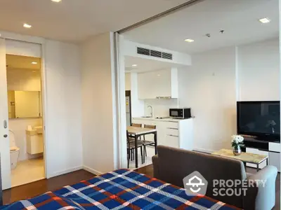 Modern studio apartment with open layout, featuring cozy living area and sleek kitchen design.