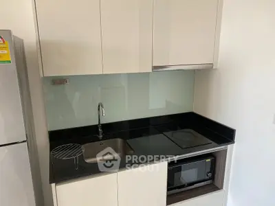 Modern compact kitchen with sleek cabinetry and built-in appliances, perfect for urban living.