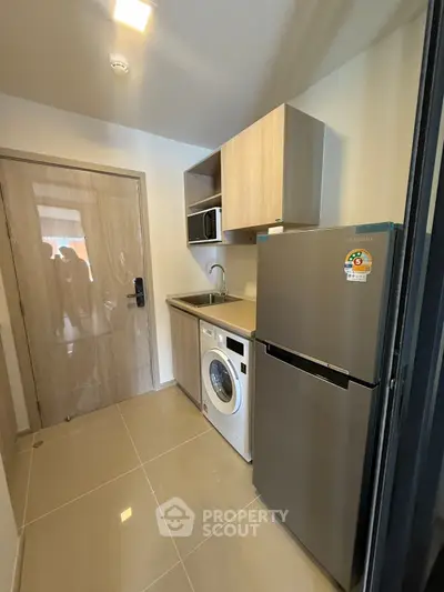 Modern kitchen with washing machine and fridge in compact layout